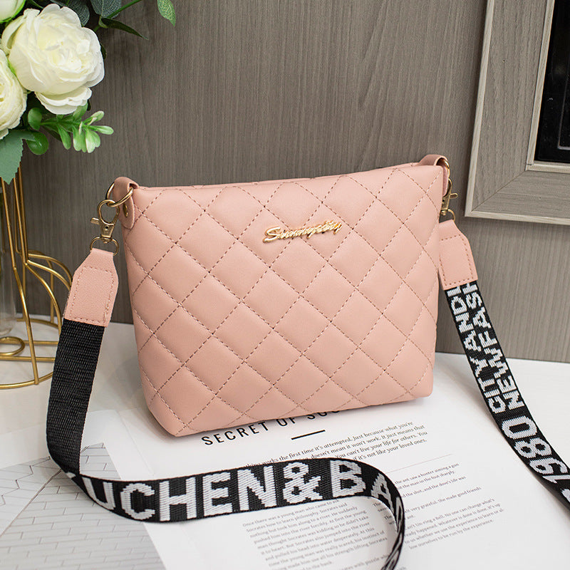 Pink diamond grid shoulder bag with wide printed shoulder strap and zip closure.